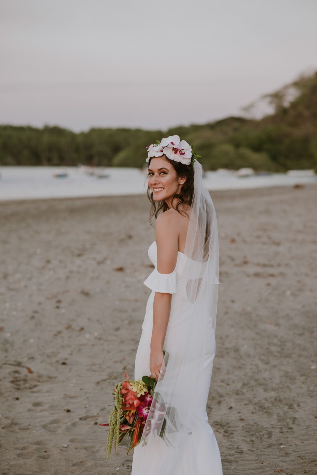 novia posando de espaldas con el mar de fondo