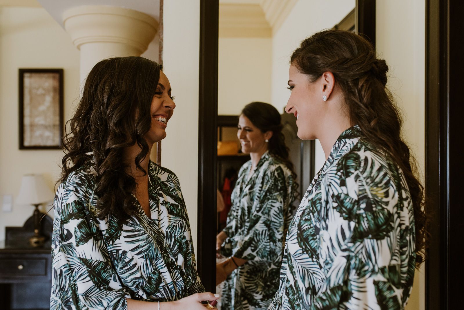 las dos novias mirándose y sonriendo durante los preparativos