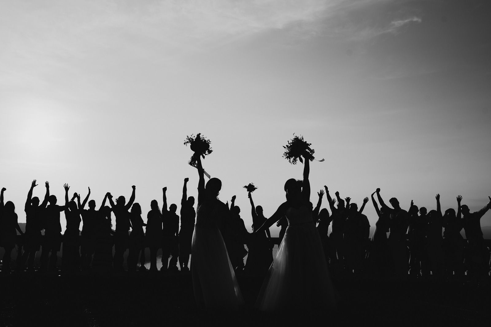 contraluz de las novias y todos sus invitados festejando