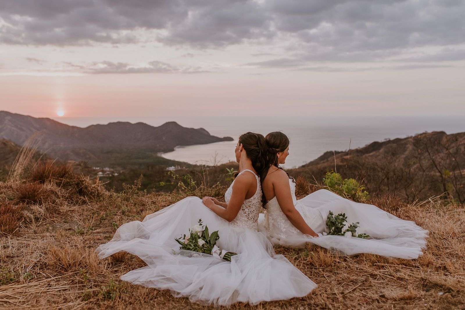 novias sentadas sobre una colina con el horizonte al fondo