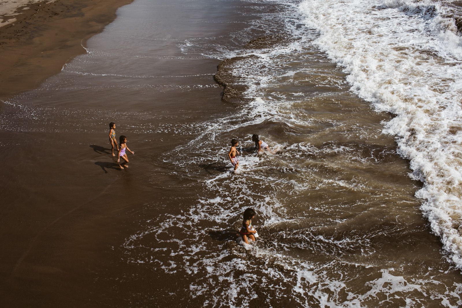 niños bañándose en la playa