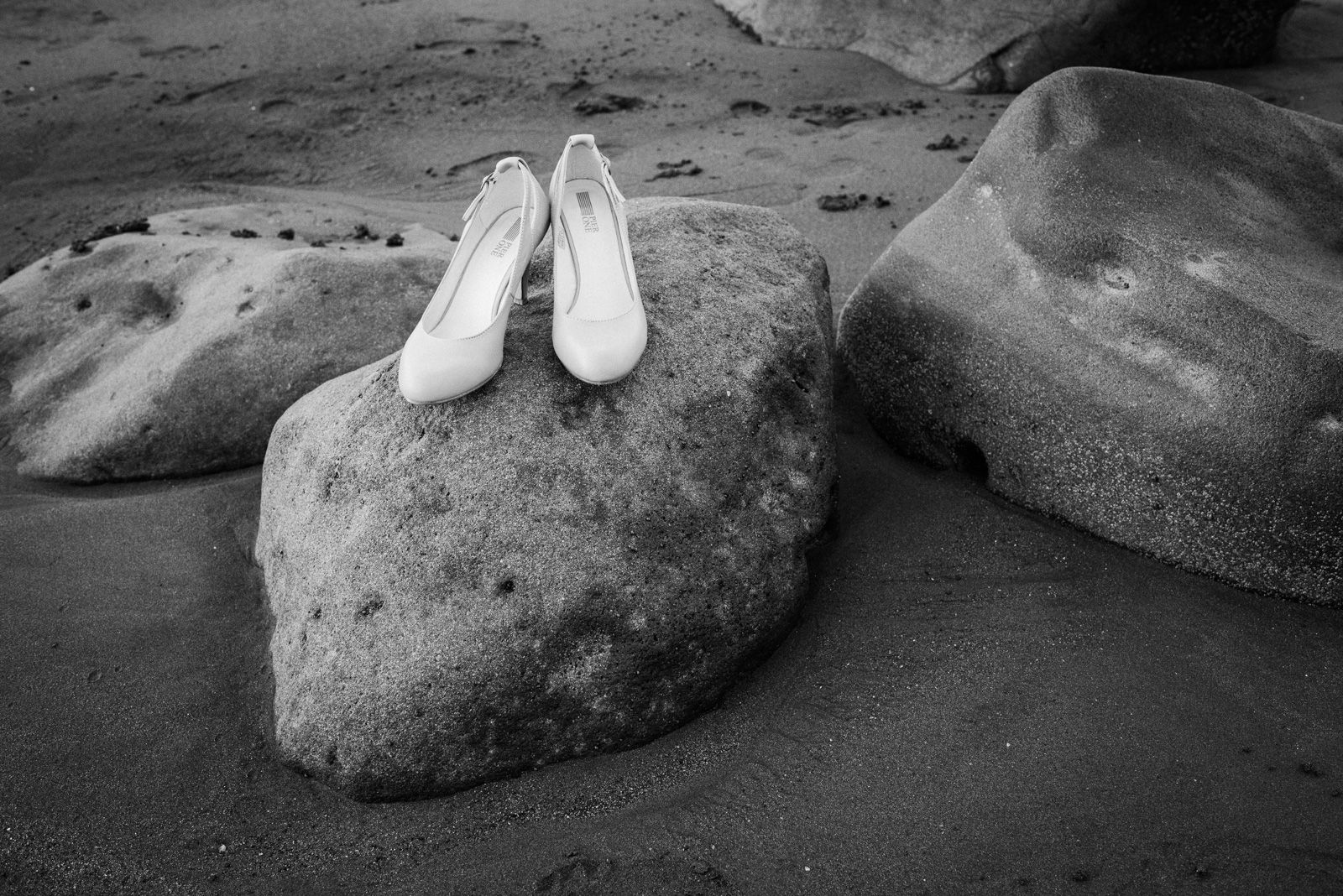 zapatos de la novia sobre una roca en la playa