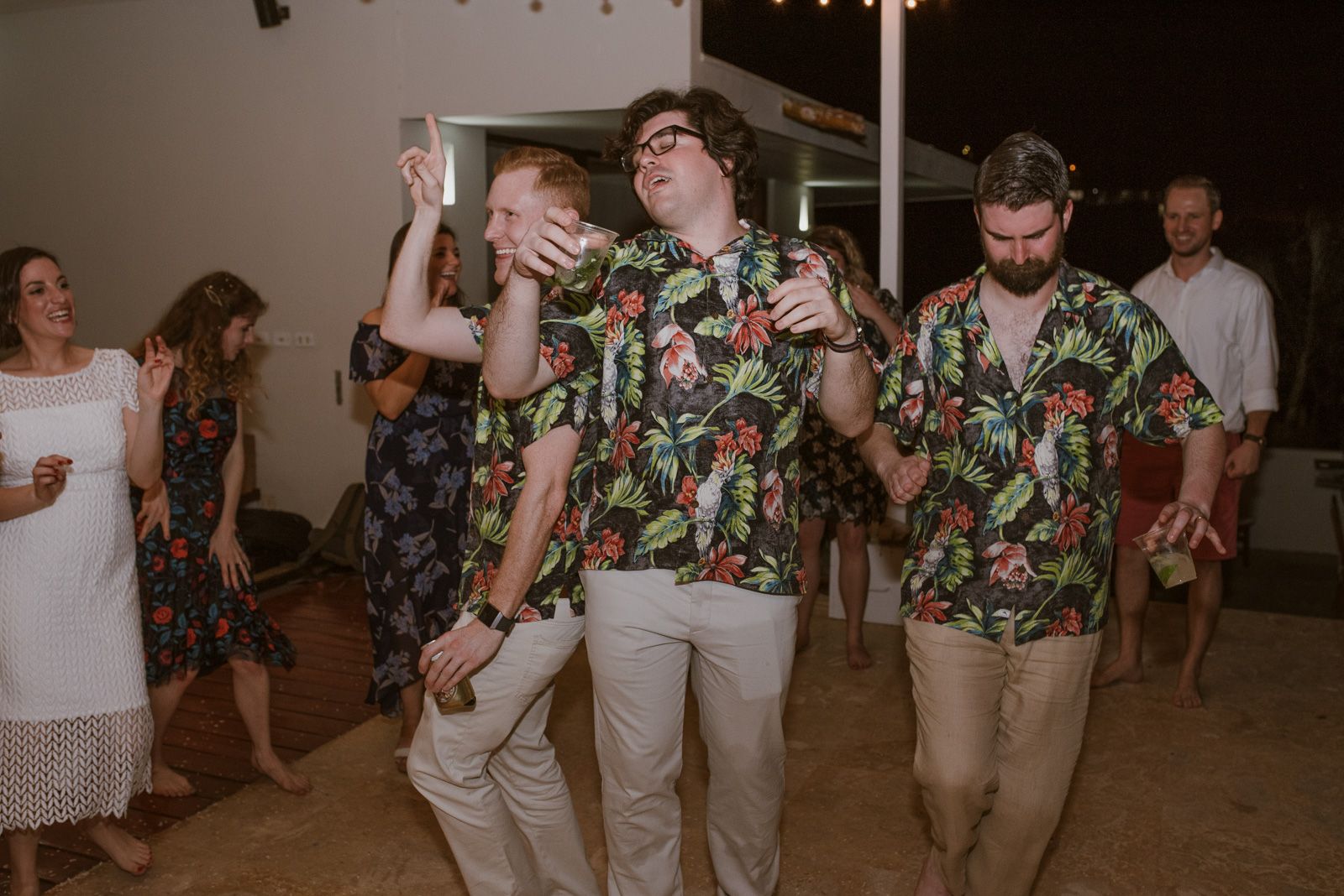 tres amigos con la misma camisa de flores bailando