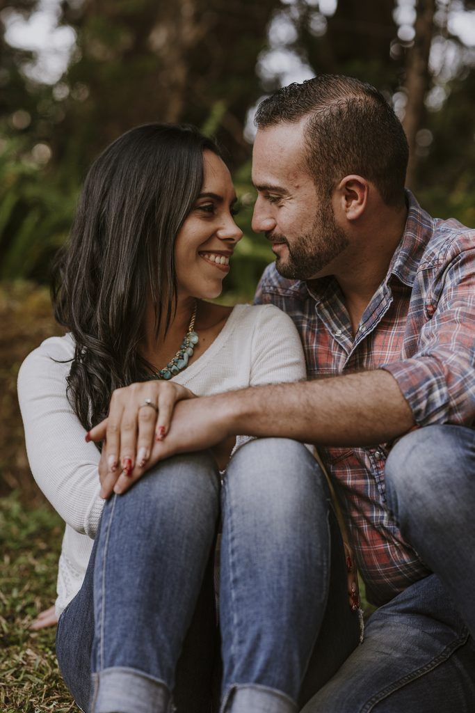 Pareja sentada mirándose y sonriendo durante su preboda