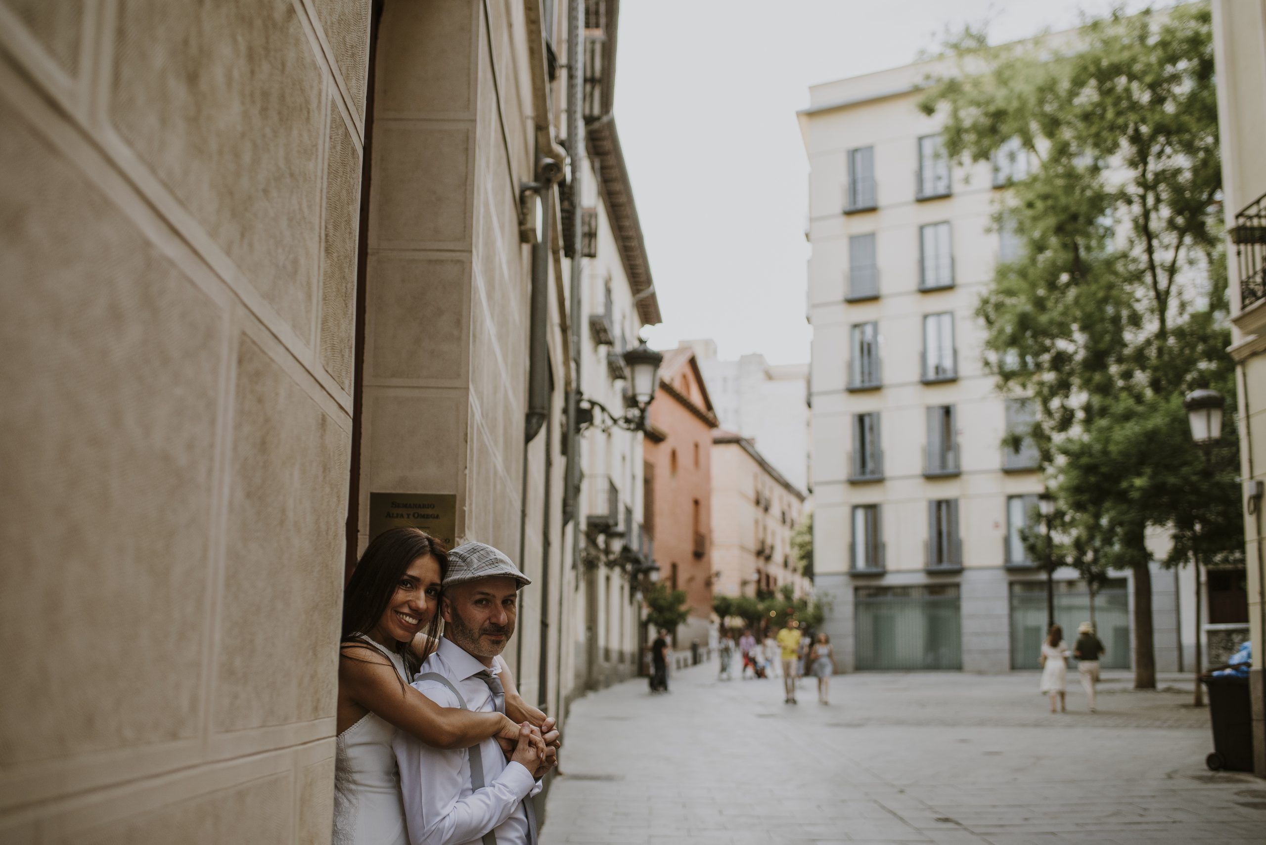 Pareja abrazada junto a una fachada en una calle de la ciudad