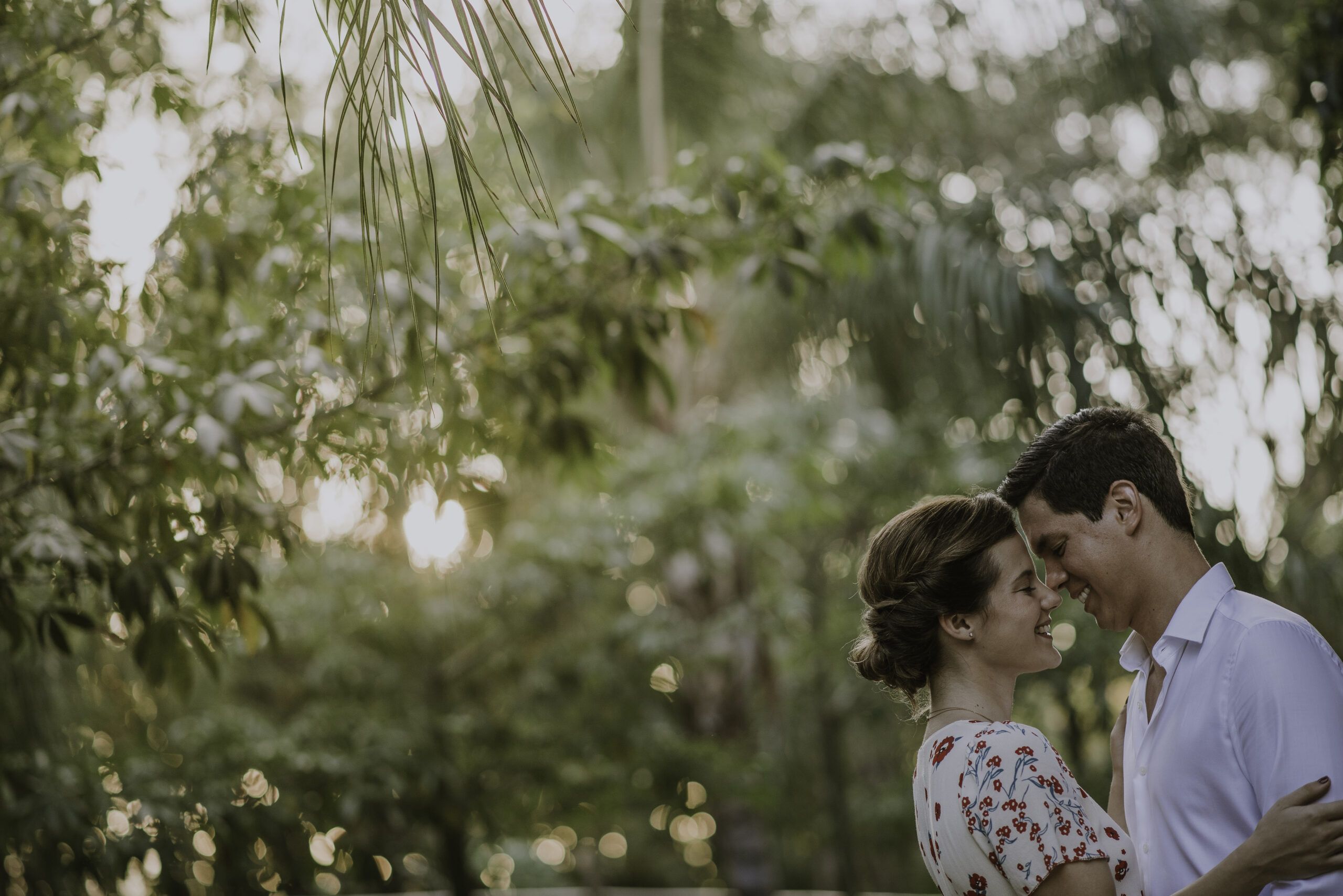Pareja frente a frente entre árboles durante una sesión de preboda