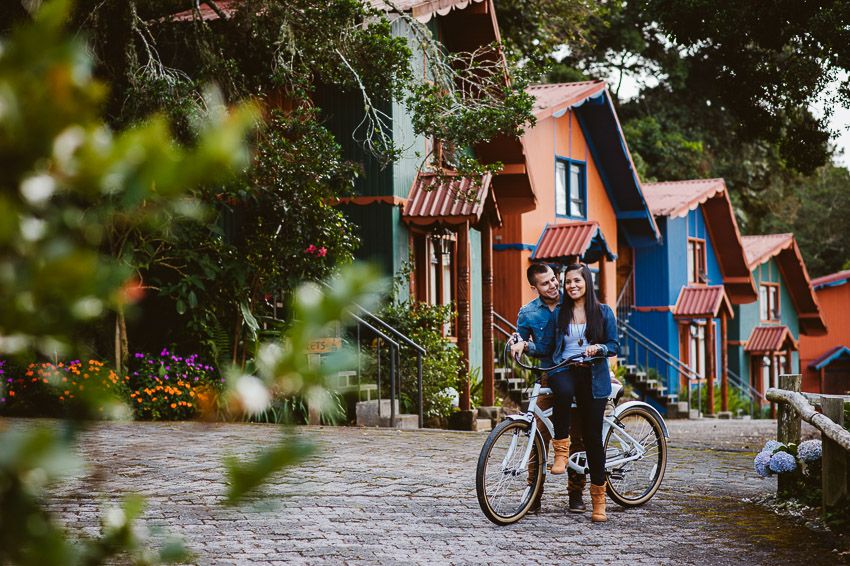 Pareja con una bicicleta frente a varias casas de colores