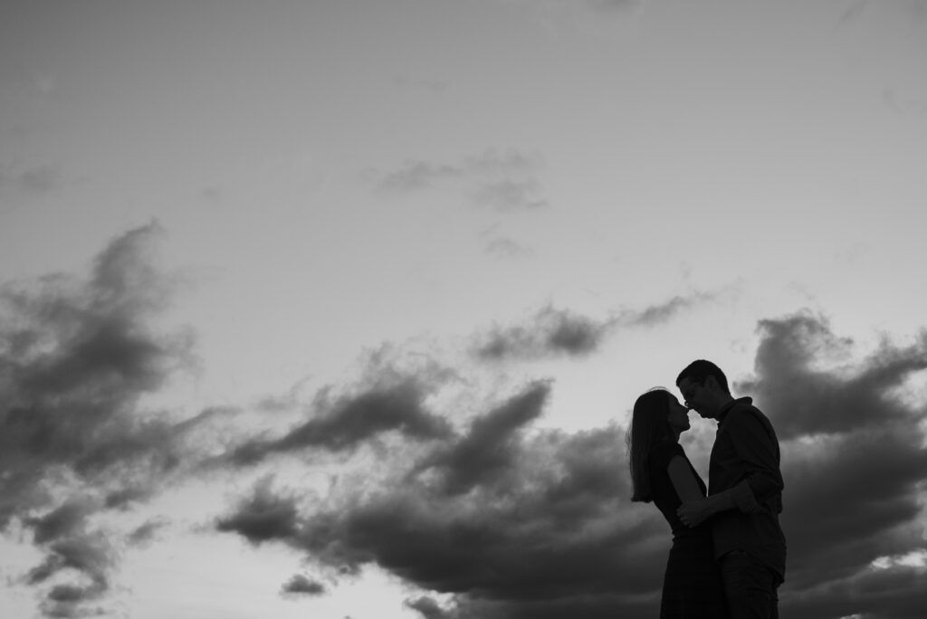 Silueta en blanco y negro de una pareja bajo un cielo nublado
