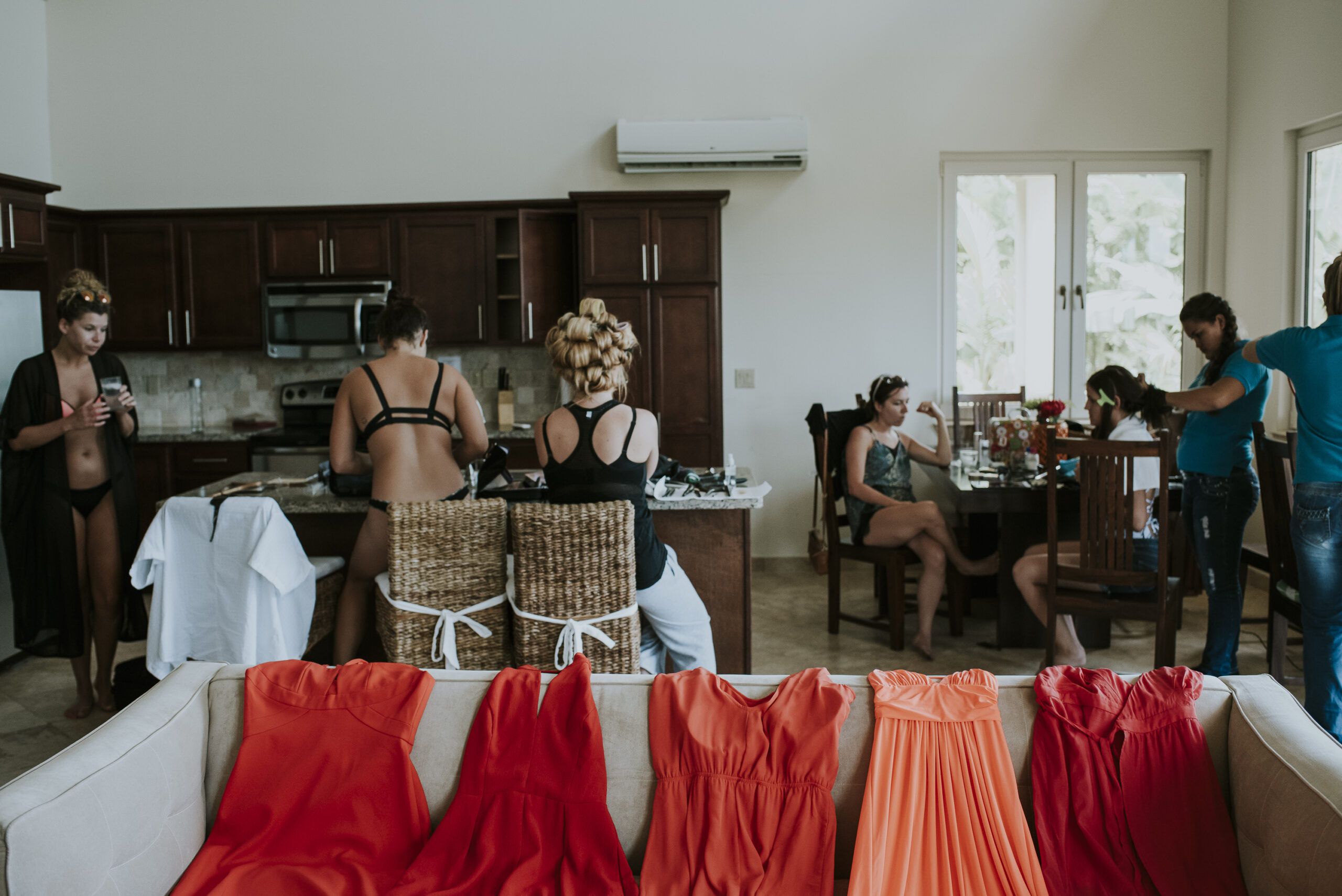Novia y acompañantes preparándose junto a los vestidos antes de la boda